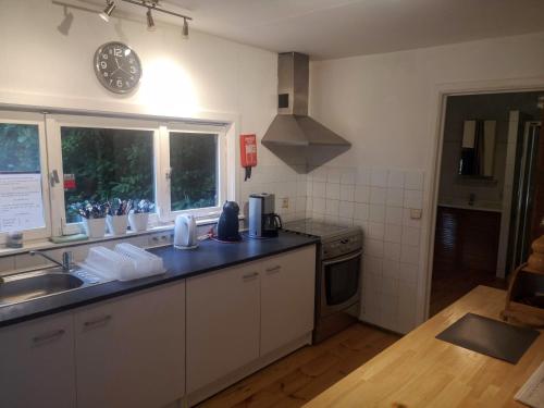 a kitchen with a sink and a clock on the wall at Chalet - Au retour vers Soi in Les Nobertins