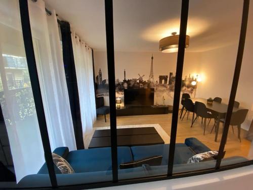 a living room with a blue couch and a table at Disneyland Dream 6 - Charmant Appartement 8 pax in Montévrain