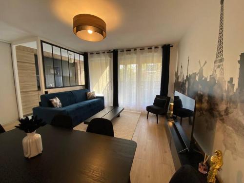 un salon avec un canapé bleu et une table dans l'établissement Disneyland Dream 6 - Charmant Appartement 8 pax, à Montévrain