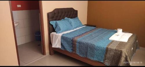 a bedroom with a bed with blue sheets and blue pillows at HOSTAL LLAUT * * in Moquegua