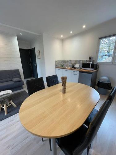 une table et des chaises en bois dans un salon dans l'établissement Les Chalets du Mancel - Chalet Tennessee - 500 m Bouleries Jump , 10 min du circuit des 24h, à Parence