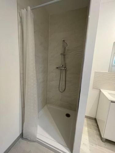 une douche avec un rideau de douche dans une salle de bain dans l'établissement Les Chalets du Mancel - Chalet Tennessee - 500 m Bouleries Jump , 10 min du circuit des 24h, à Parence