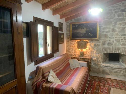 a living room with a couch and a stone fireplace at Casa tipica sarda in Gonnosnò