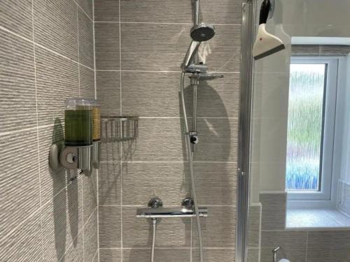 La salle de bains est pourvue d'une douche et d'une porte en verre. dans l'établissement Sophisticated & Contemporary Modern House for 6 Pass the Keys, à Chapel-en-le-Frith
