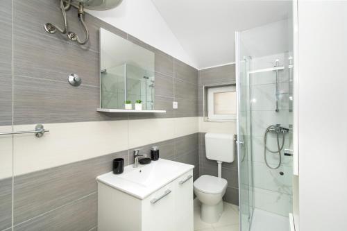 a bathroom with a toilet and a sink and a shower at Villa Natura Piedra in Slivno