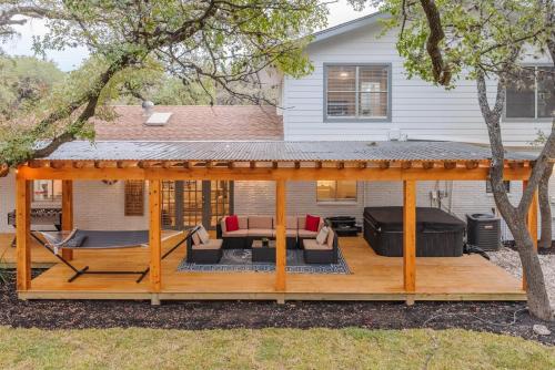 una terraza de madera con cenador en Luxurious Home With Hot Tub & Tree Deck By 6flags, en San Antonio