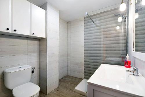 biała łazienka z toaletą i umywalką w obiekcie Apartamento Ribera del Marisco w mieście El Puerto de Santa María