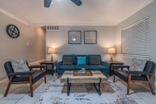 a living room with a blue couch and two chairs at Beautiful Apartment at The Botanical Gardens #1 in San Antonio