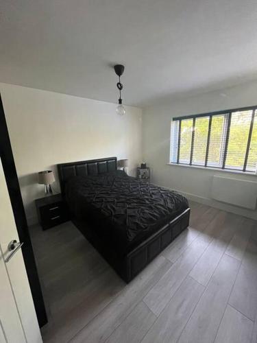 a bedroom with a black bed in a room at 1-bed apartment w/ electric fireplace in London