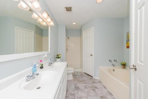 uma casa de banho com uma banheira, um lavatório e um WC. em Superb House By Seaworld, Private Pool & Gameroom em San Antonio