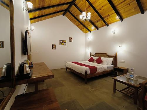 um quarto com uma cama, uma mesa e uma televisão em Hidden Trails Ramgarh, Nainital em Rāmgarh