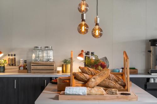 a table with a tray of loaves of bread at Aiden by Best Western Trondheim Airport in Stjoerdal
