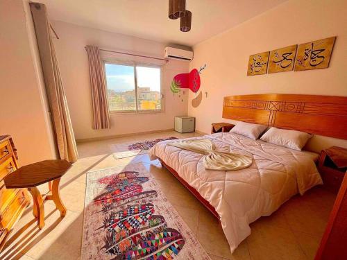 1 dormitorio con 1 cama grande y 1 alfombra en 5-BRS Villa Steps from Beach Cozy vibes en Ain Sokhna