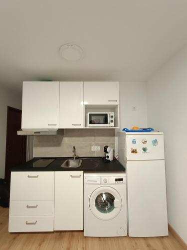 a small kitchen with a washing machine and a microwave at Casa blanca in Santa Coloma de Gramanet