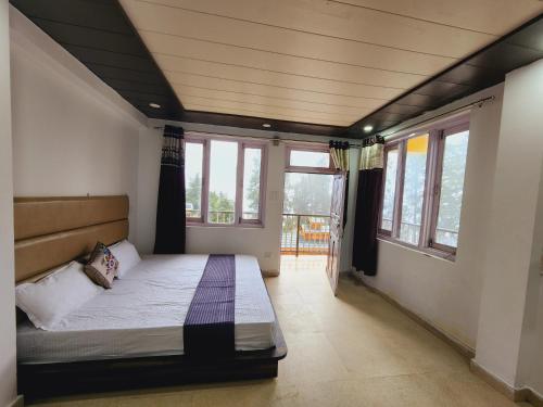 um quarto com uma cama num quarto com janelas em Green Valley-Nature`s Oasis em Dalhousie