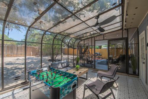 una casa di vetro con un tavolo da ping pong di Beautiful Home With Sunroom, Gameroom, Yard & Bbq a San Antonio