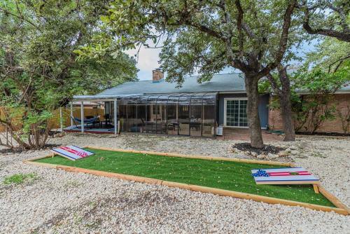 a backyard with a house with a tree at Beautiful Home With Sunroom, Gameroom, Yard & Bbq in San Antonio
