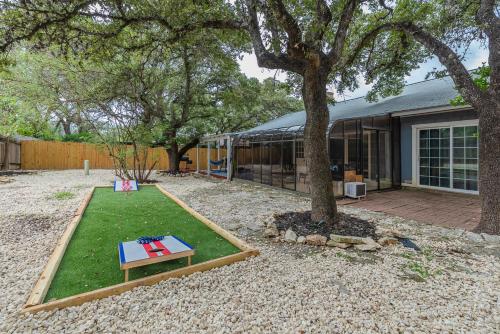 a backyard with a table and a tree at Beautiful Home With Sunroom, Gameroom, Yard & Bbq in San Antonio
