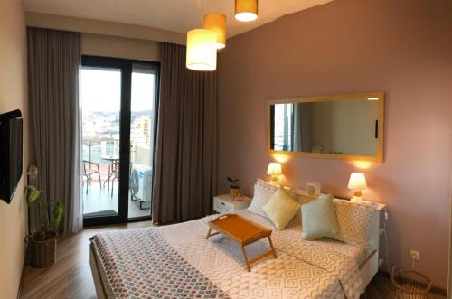 a bedroom with a bed with a mirror and a balcony at Ameri Plaza Green Apartments in Tbilisi City