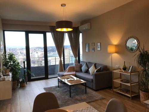 a living room with a couch and a table at Ameri Plaza Green Apartments in Tbilisi City