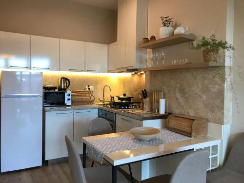 a kitchen with a table and a white refrigerator at Ameri Plaza Green Apartments in Tbilisi City