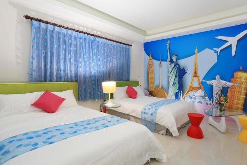 a bedroom with two beds and a mural of the eiffel tower at Dania Garden in Luodong