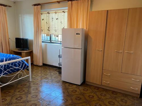 a kitchen with a white refrigerator in a room at Aspley bedroom & share bathroom with other guests in Brisbane