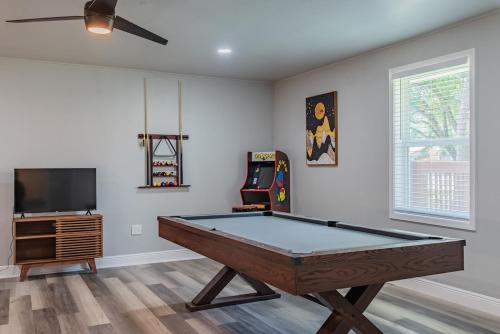 a room with a pool table and a tv at Stunning Pool Overlooking Golf Course & Game Room in San Antonio