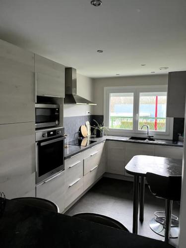 a kitchen with stainless steel appliances and a table at Maison avec jardin 