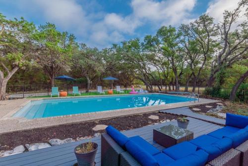 a swimming pool with a blue couch and trees at Luxury House By Fiesta Texas & Seaworld With Pool in San Antonio