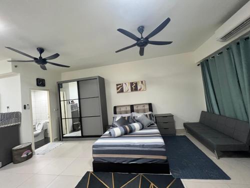 Schlafzimmer mit zwei Deckenventilatoren und einem Bett in der Unterkunft Edusphere Suites, University of Cyberjaya near Tamarind Square in Cyberjaya