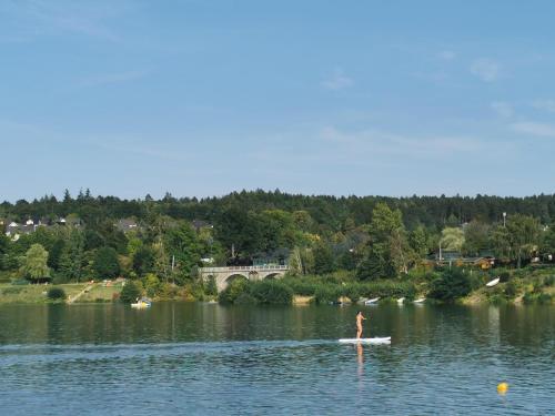 a person on a paddle board on a lake at Gartenwohnung Paulsdorf in Dippoldiswalde