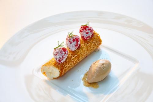 a plate of food with corn and strawberries on it at Hotel Ketschauer Hof in Deidesheim