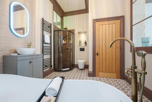 a bathroom with a tub and a shower and a sink at The Florin - 1 Bedroom Apartment in Central Bristol by Mint Stays in Bristol