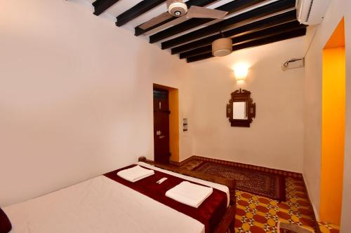 Villa D Jems -A Heritage Home stay في بونديتْشيري: غرفة نوم بسرير في غرفة