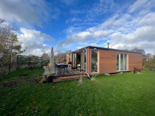 Cabaña de madera pequeña en un campo de hierba en Moderne bungalow voor 6 personen, en Julianadorp