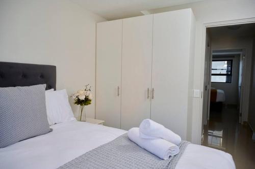 a bedroom with a white bed with towels on it at 401@The Millennial in Durban
