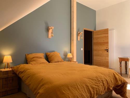 een slaapkamer met een groot bed met een blauwe muur bij Ferme de la Croix Blanche, Vercors (4 ch, 8 pers) in Méaudre