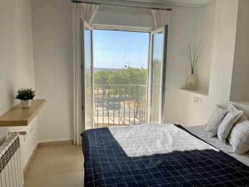 1 dormitorio con cama y ventana grande en Two bedroom Apt., Hacienda Riquelme Golf Resort en Murcia