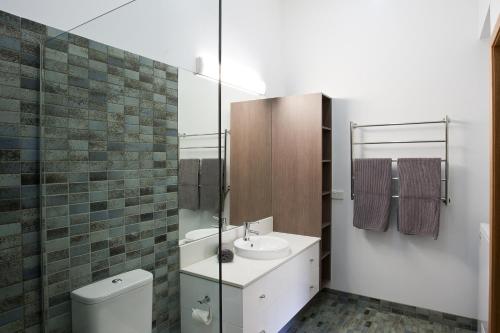 La salle de bains est pourvue d'un lavabo et de toilettes. dans l'établissement Altitude Apartments, à Falls Creek