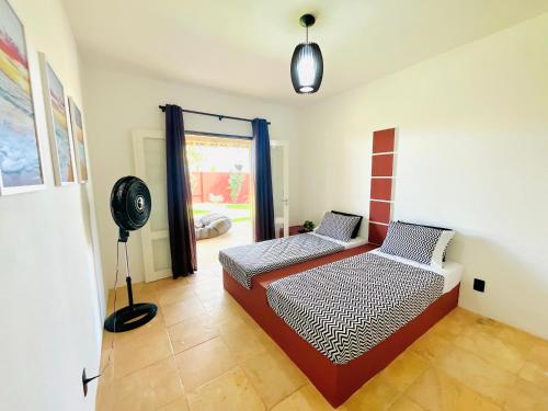 a room with a bed and a fan in it at Kitesurf Oasis Maracajaú in Maracajaú