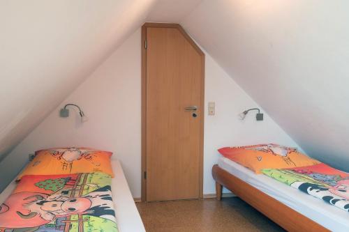 two beds in a attic room with a door at Schelterhof in Wunsiedel