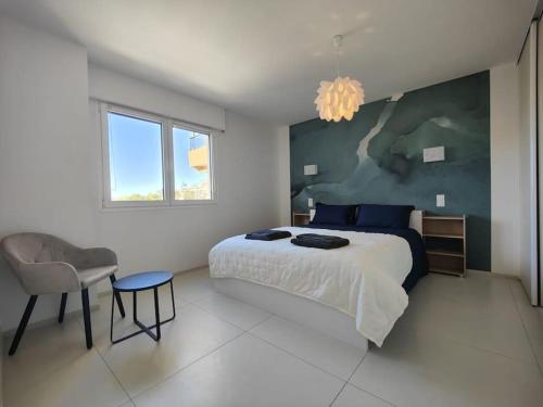 une chambre avec un grand lit et une chaise dans l'établissement Cannes Vue mer T2 61m²+ parking, à Cannes