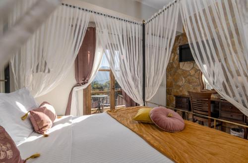 um quarto com uma cama com almofadas em Archontiko Fiamegou Hotel&Spa em Synikia Mesi Trikalon