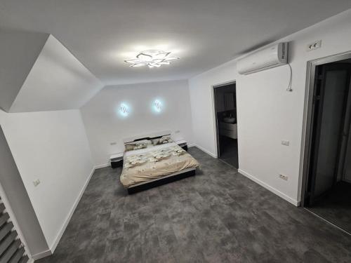 1 dormitorio con 1 cama en una habitación blanca en Comfy & Cozy Apartment 3, en Rădăuţi