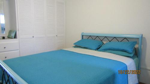 a blue bed with blue pillows in a bedroom at Cozy, quiet 1 bedroom 2A near Beach near US Embassy in Bridgetown