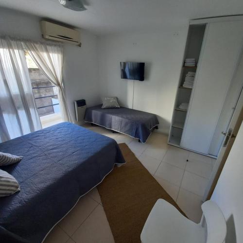 1 dormitorio con 2 camas y TV. en Dpto Estudio en Gualeguaychú