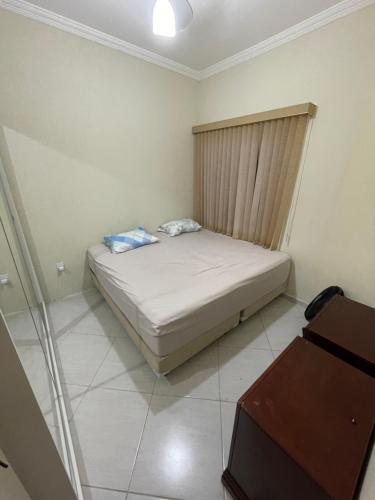 Casa com piscina em condomínio في كاشويرا باوليستا: غرفة نوم صغيرة مع سرير وتلفزيون