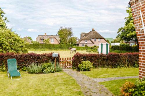 a yard with a blue chair and a house at Ferienhaus VOGELKIEKER in Midlum