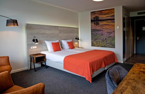 een hotelkamer met een groot bed en een stoel bij Hotel Restaurant Eeserhof in Ees